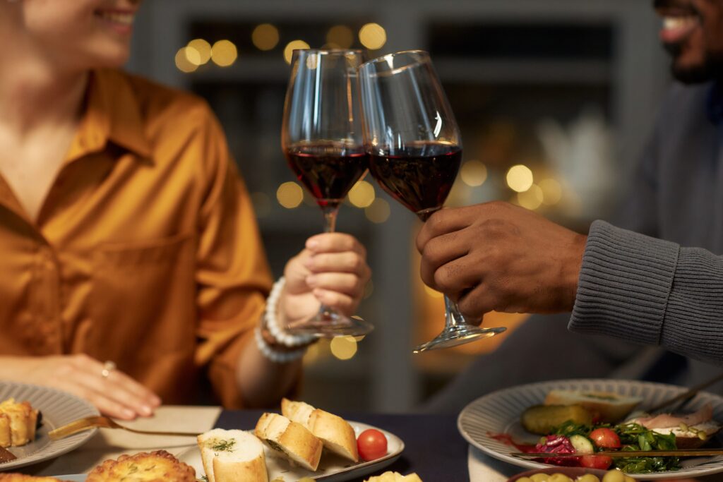 couple toasts glasses of red wine on romantic getaway in Stillwater MN