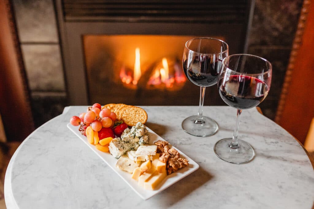 Things to do in Stillwater, the Water Street Inn cozy glass of wine and charcuterie board by the fire 
