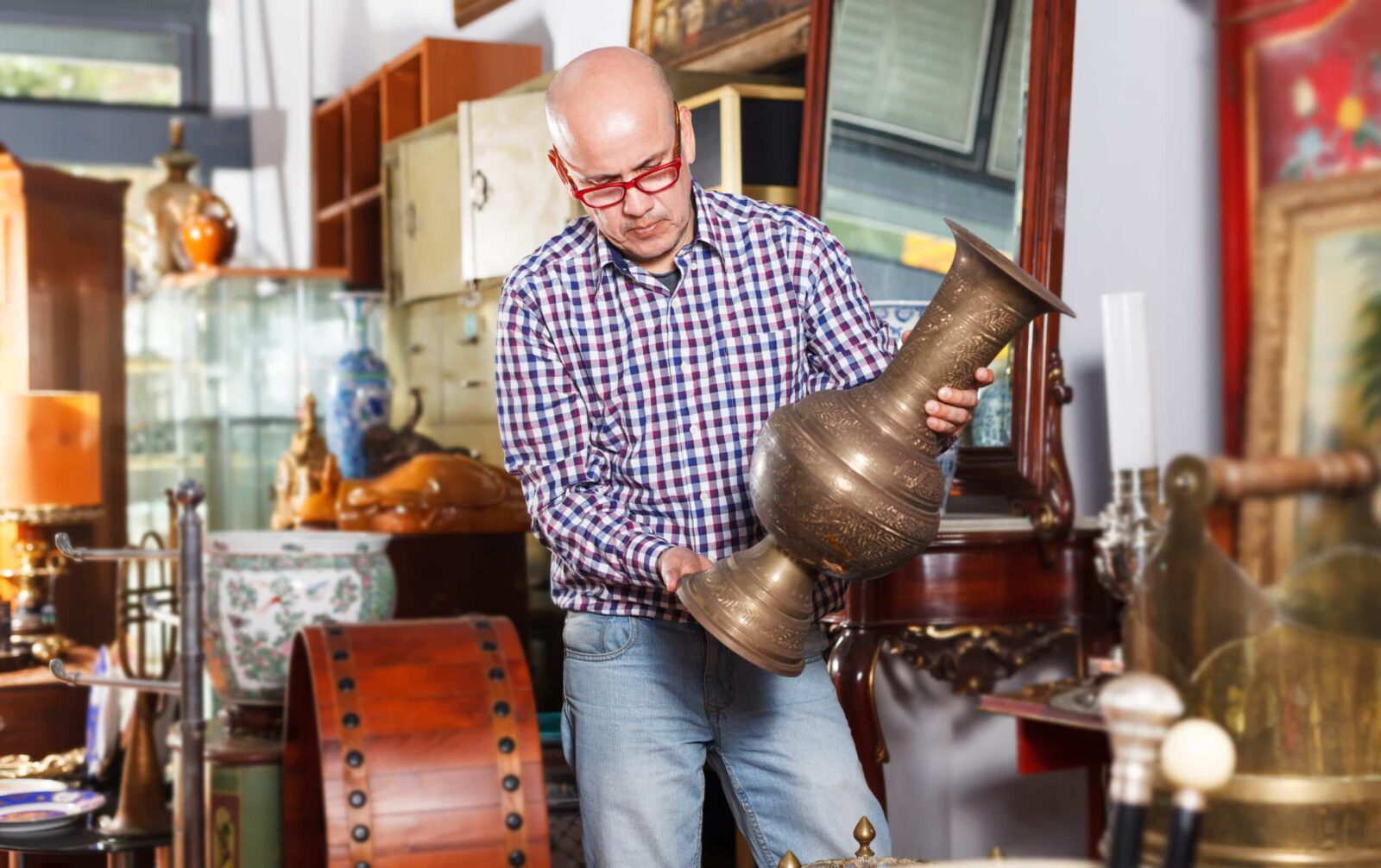 Man holds bronze vase at Stillwater antique stores.